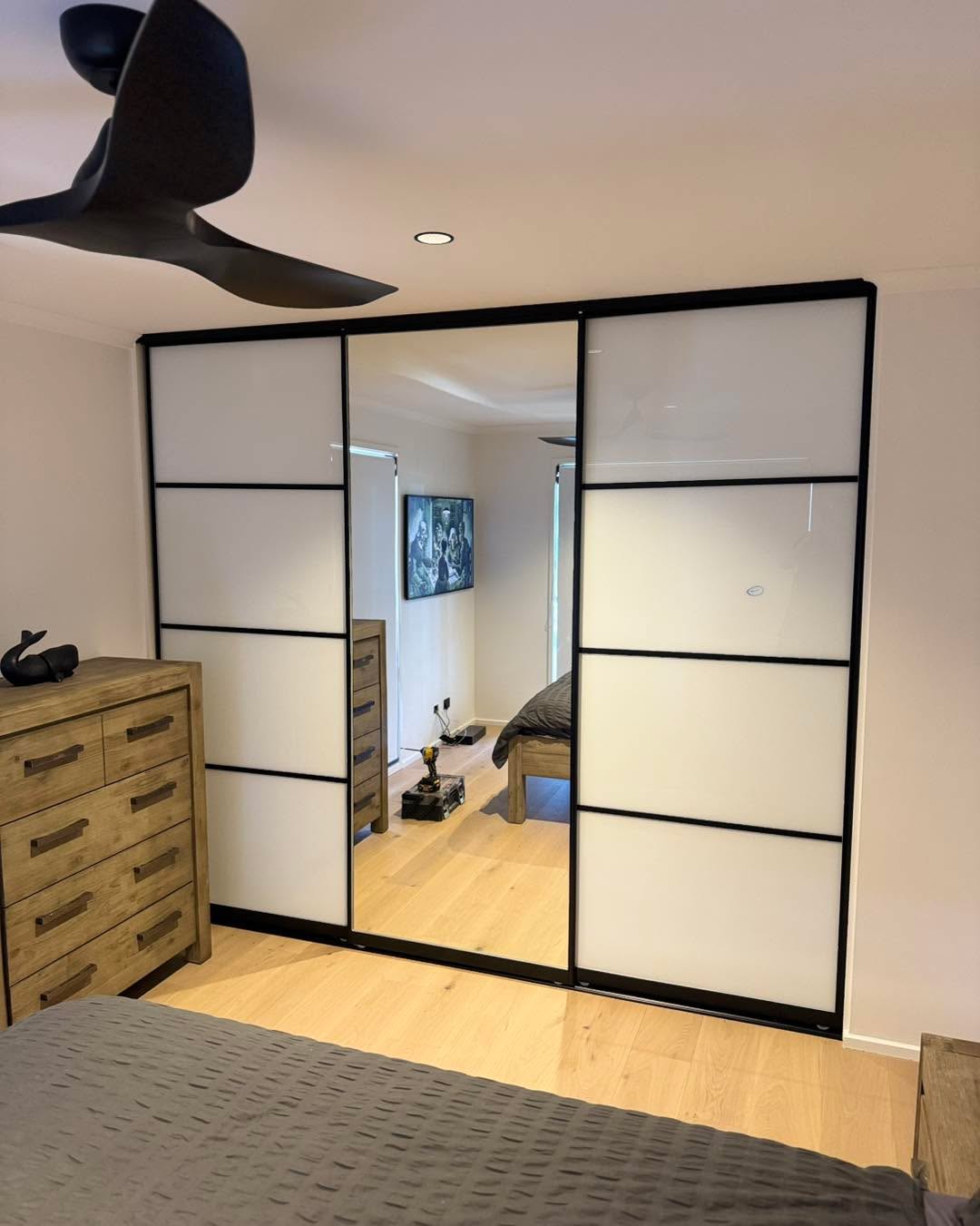 Modern bedroom with black-framed sliding wardrobe doors